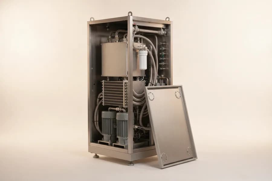 A rack-height coolant distribution unit with its front panel removed, showing two vertical circulating pumps, a brazed-plate heat exchanger, a cartridge filter housing and braided hoses.
